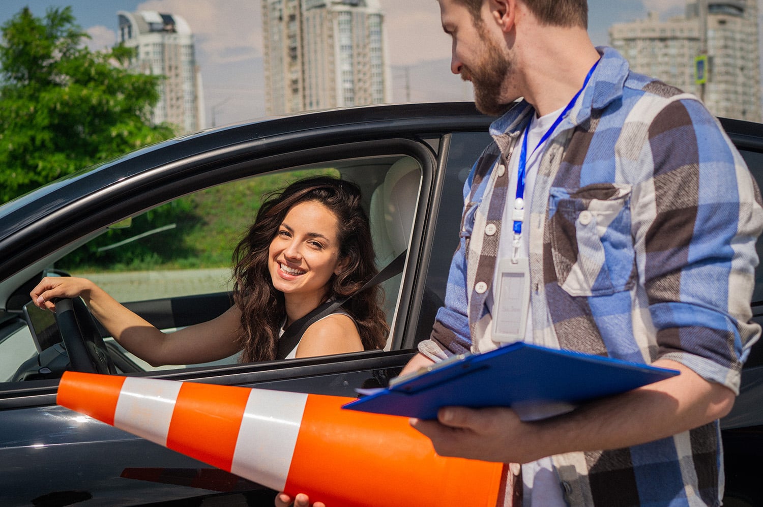 Male Instructor Holding Traffic Cone And Form. Young Woman Sitting In The Car Before Driving Lesson. Driving Test, Driver Courses, Exam Concept